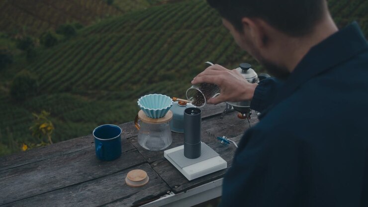 Man Preparing Fresh Coffee Outdoors Overlooking Tea Plantation