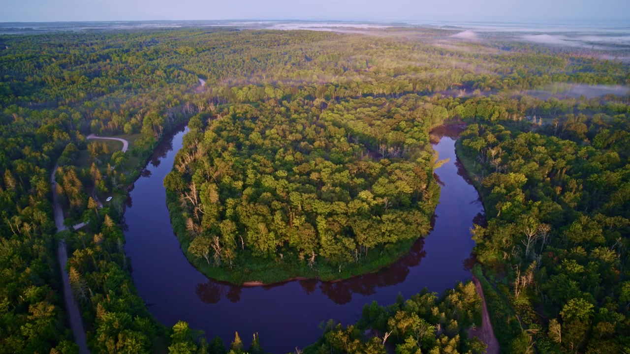Prise de vue par drone montrant une grande forme de fer à cheval où la rivière Manistee serpente de manière spectaculaire