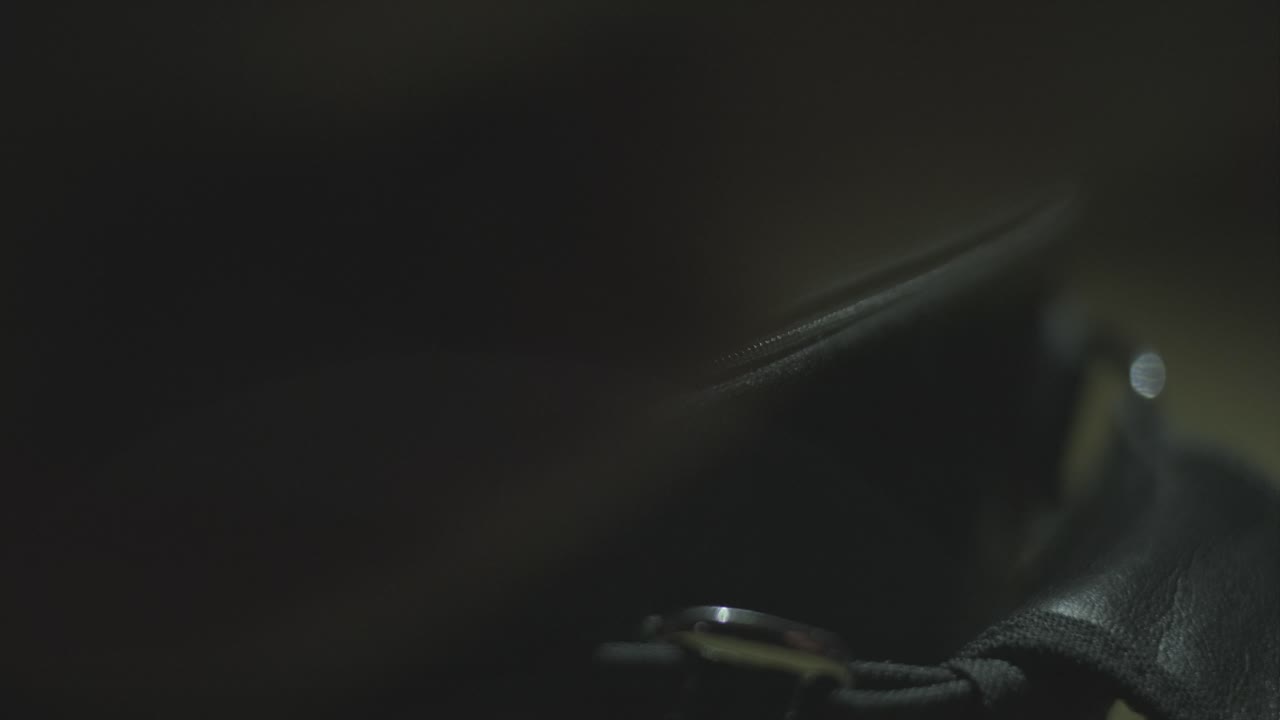 4k shot of opening a zipper of a retro camera bag in low light