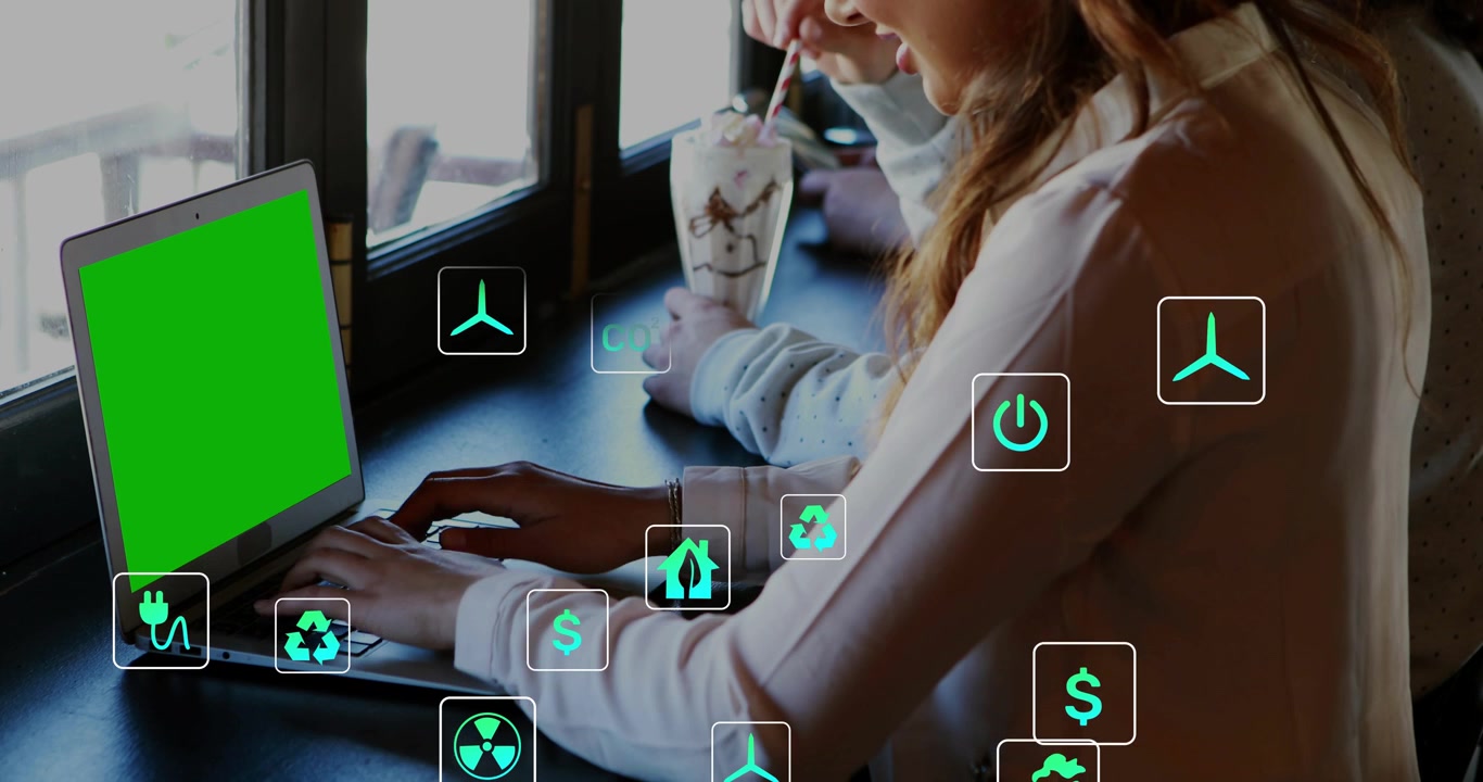 Donna che digita su un laptop verde, un collega che mescola una tazza, con icone di energia che salgono sopra le mani per una migliore comprensione.