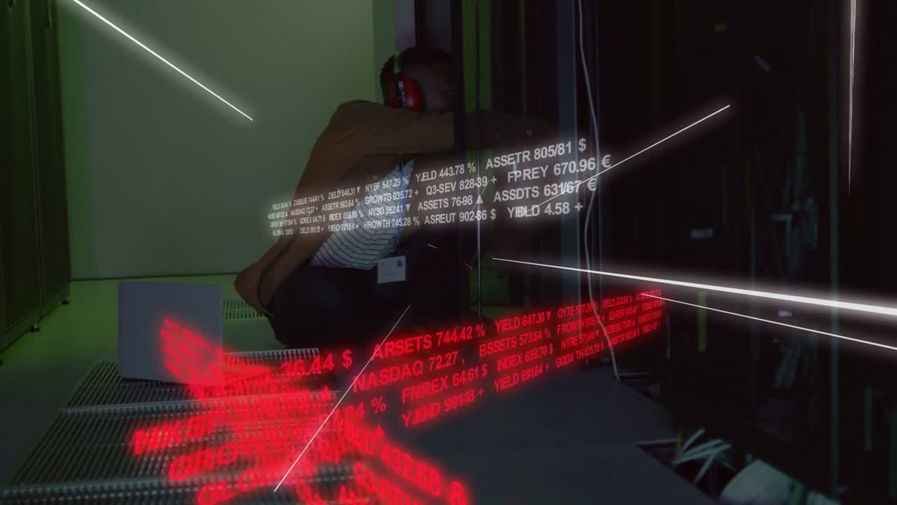 Reacting to moving data, tech in striped top red headset crouching in demo room tracking tickers