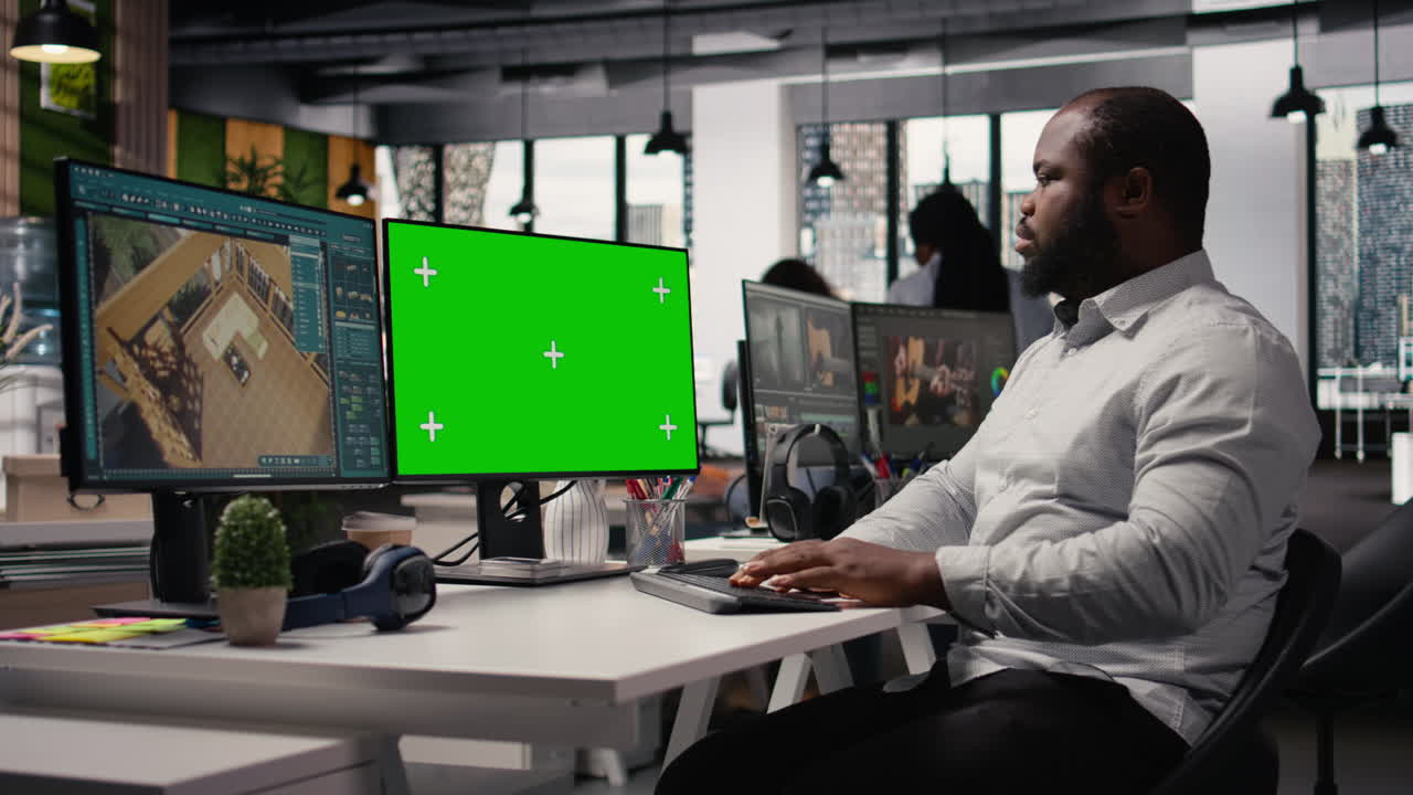 Greenscreen og arkitektursoftware på dobbeltskærme i kreativt bureau