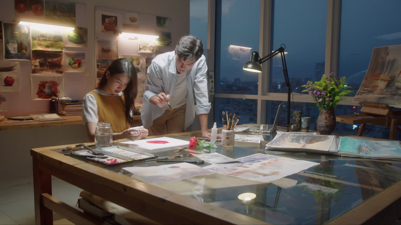 Asian Painter Teaching Female Student in Art School