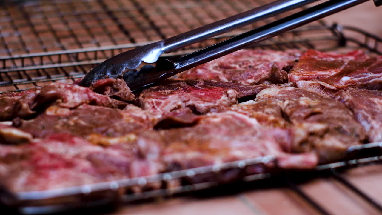 Costolette d'agnello disposte sulla griglia per il barbecue.