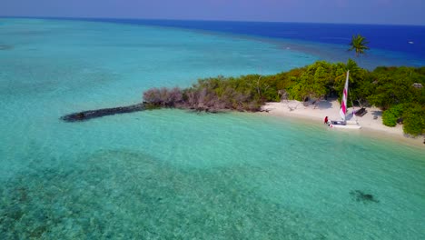 A-Beautiful-Green-Island-Surrounded-by-Blue-Waters-and-Clear-Blue-Sky-In-the-Background-in-Thailand---Aerial-shot