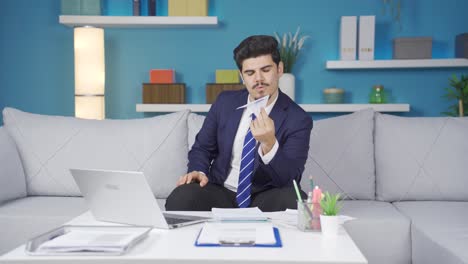 Thoughtful-home-office-worker-man-playing-with-paper-airplane.