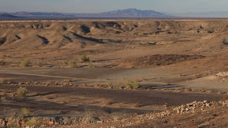 a male hiker treks through the arizona desert, seen in a wide shot from afar