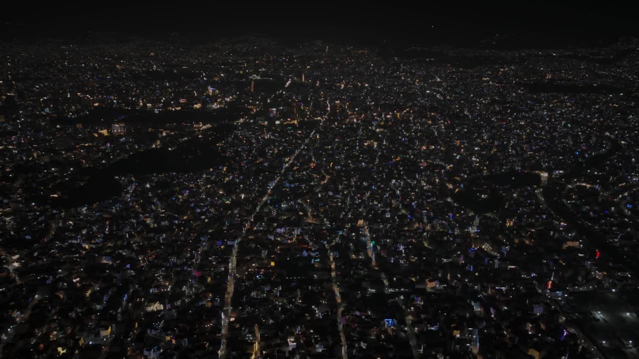 Aerial night footage of Kathmandu city during Diwali (Tihar), featuring the illuminated Dharahara Tower and glowing skyline filled with festive lights, showing Nepal’s vibrant cultural celebration
