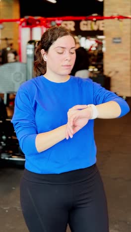 woman checking smartwatch during gym workout