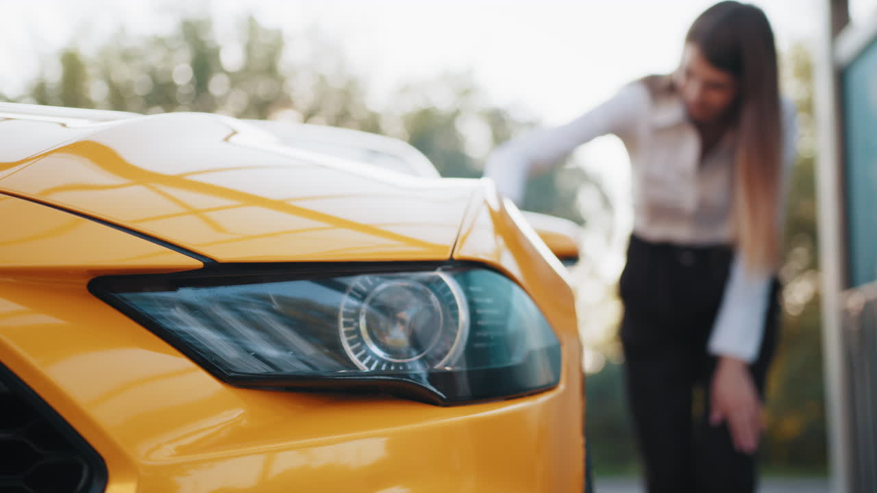 노란색 스포츠카를 보고 있는 여자