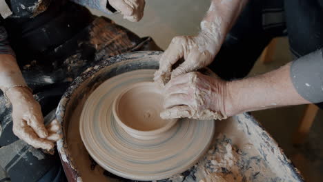 pottery class: hands shaping clay on potter's wheel