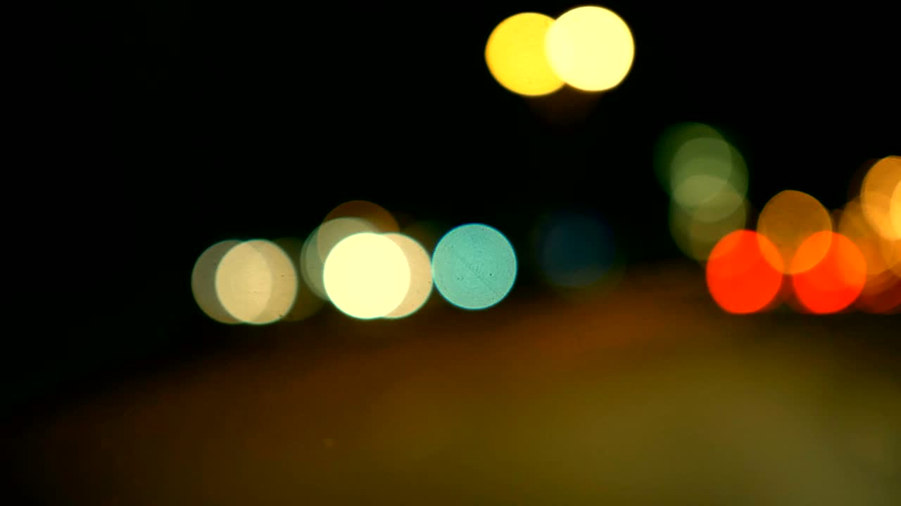 conducir un coche a través de la carretera de la noche, la autopista. luces desenfocadas calle de los ángeles resumen. ciudad fondo borroso. movimientos círculos bokeh de tráfico nocturno.