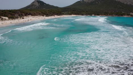 Cala-Aguila-Mit-Großen-Wellen-Und-Klarem-Wasser,-Das-Auf-Den-Strand-Stürzt