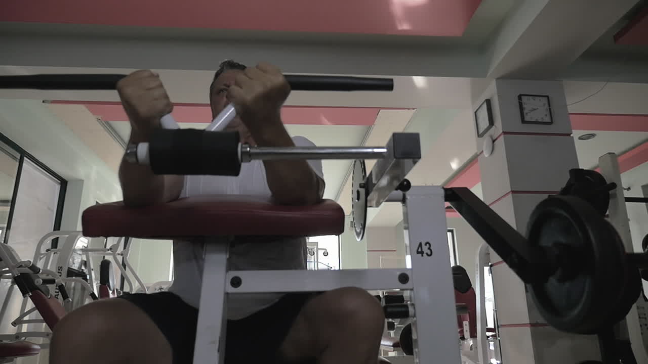 hombre cansado terminando ejercicios en la máquina de levantamiento de pesas