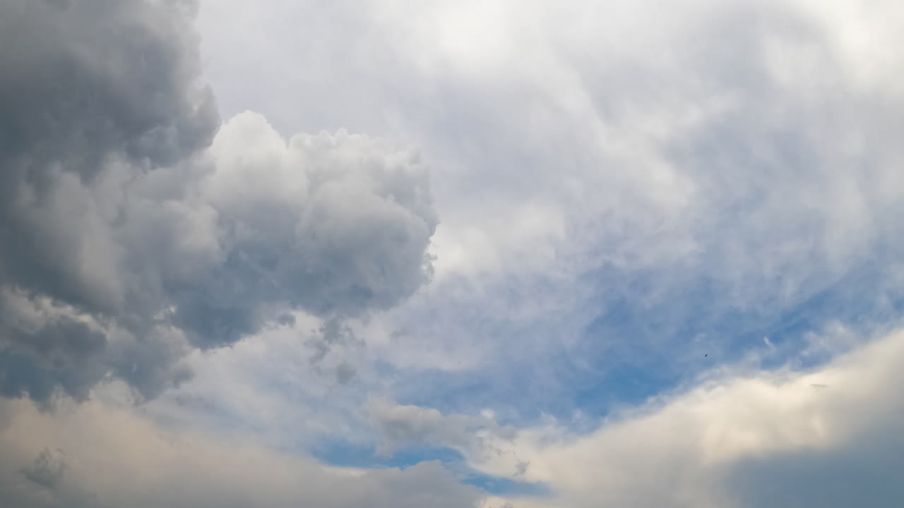 Grey cumulus clouds are disappearing in the wind. Cirrus cloudscape covering the sky. Timelapse.