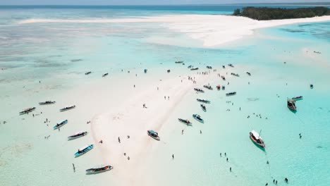 4K-flying-drone-footage-above-white-sandbanks-coast-with-beautiful-transparent-rippled-waves-washing-coral-reefs-atoll-near-Mnemba-Island,-Tanzania