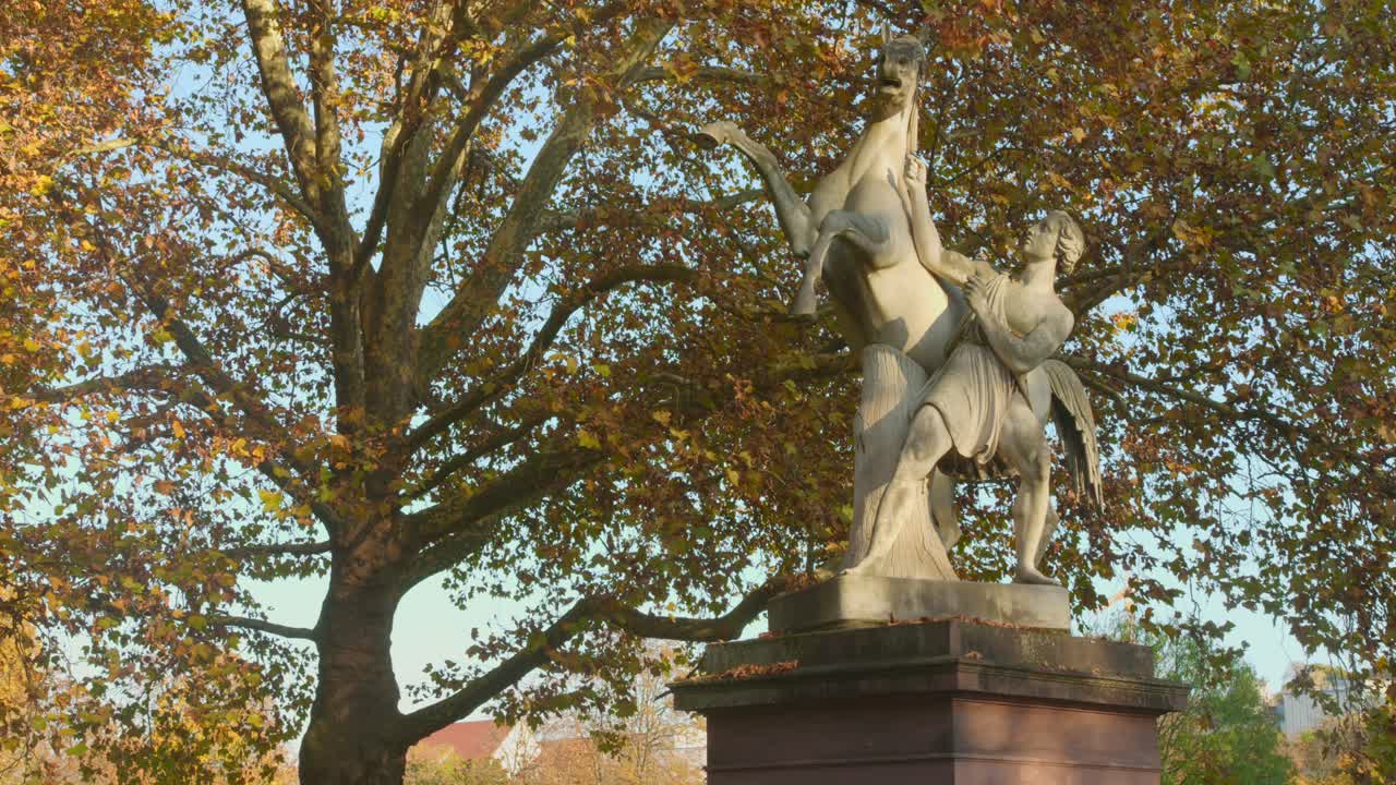 Classical Sculpture of a Man Taming a Horse in a Park