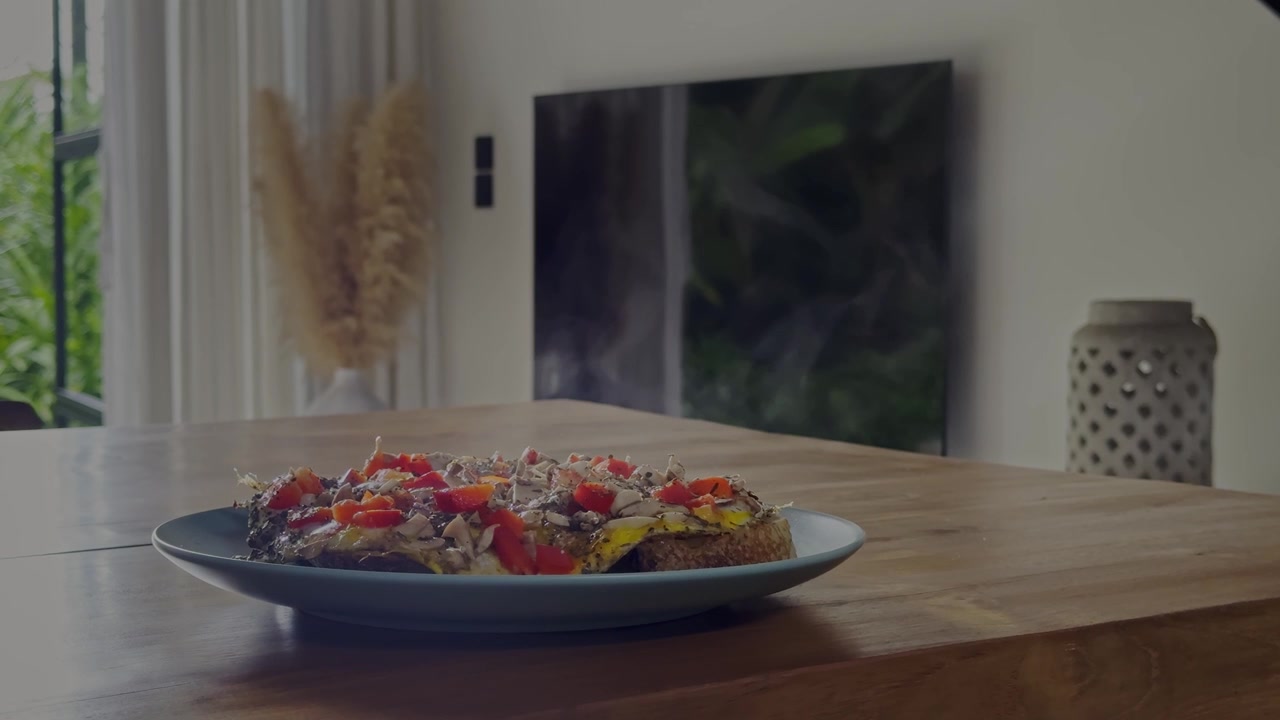 Vapor subindo de uma refeição recém-preparada com ovo, pimentão vermelho e cogumelos em torrada de pão de fermentação natural, servida em uma sala de estar moderna e iluminada com luz natural aconchegante.