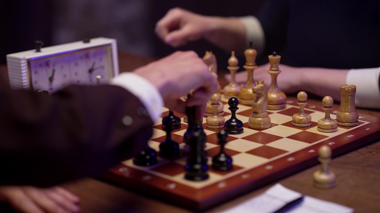 Gros plan sur des joueurs d'échecs effectuant des coups et notant la partie