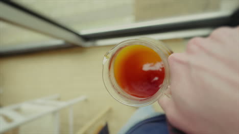 close-up of coffee being swirled in a glass container from an overhead perspective