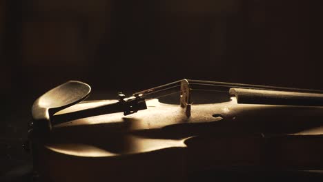 close up of old violin, dramatic light changes over the instrument , classical symphony music video footage