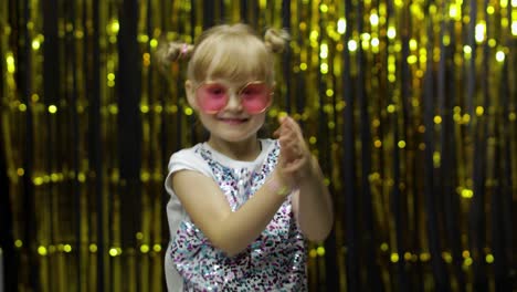 Child-kid-dancing,-celebrating-victory,-fooling-around.-Girl-posing-on-background-with-foil-curtain