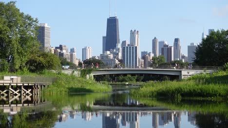 people crossing bridge with chicago skyline in distance