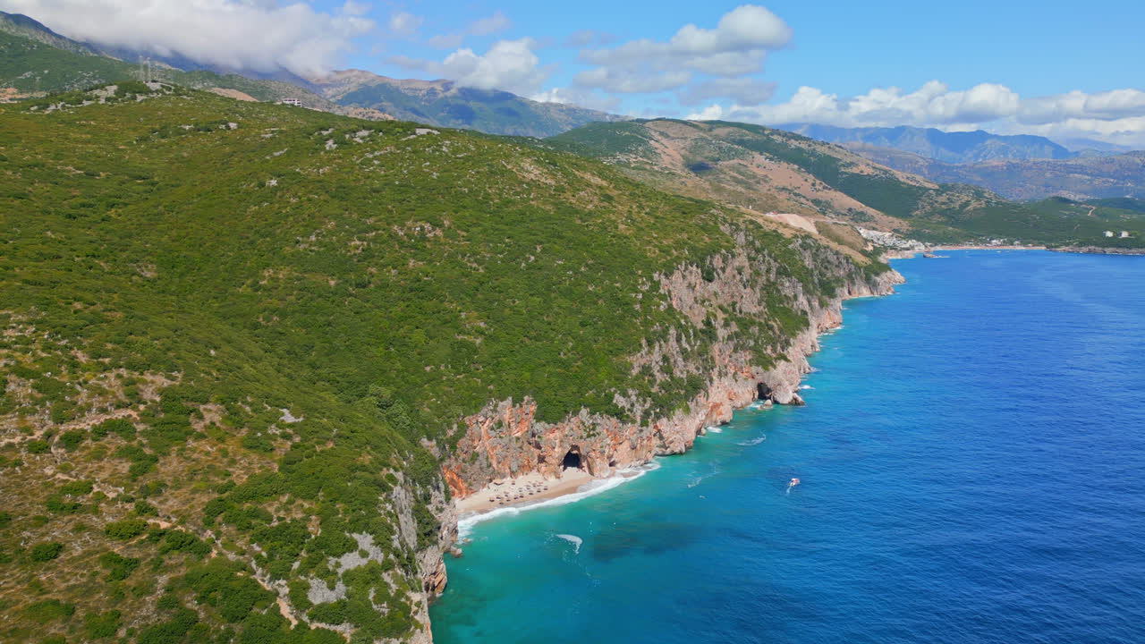 하르미, 알바니아의 동굴이 멀리 보이는 gjipe 해변 위를 날아다니는 항공 드론의 뒤로 움직이는  ⁇