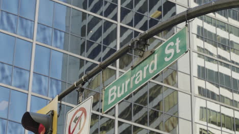 Burrard-Street-crossing-in-Vancouver,-street-sign-with-buildings-in-the-background,-handheld-parallax