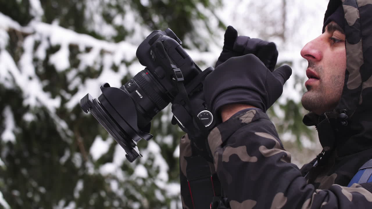 Photographer in snowy forest, close up while taking photos