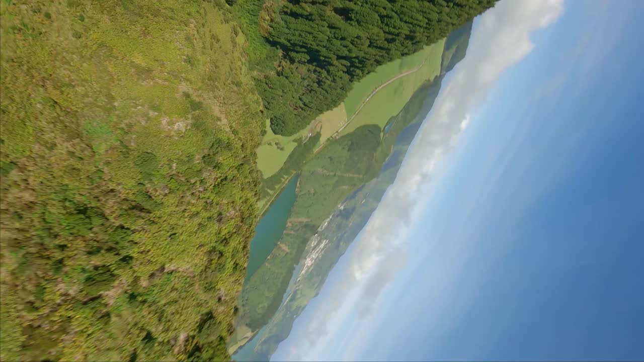fpv vertical disparado sobre el gran lago y las colinas en el verano