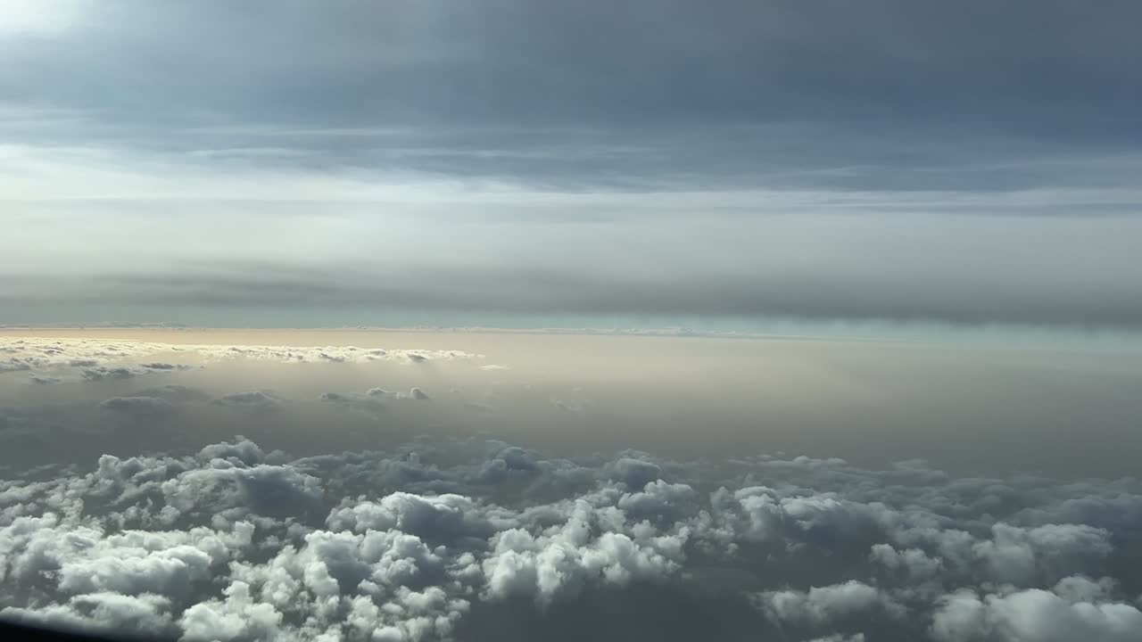 Cockpit lateral view of some clouds during sunrise, with a dusty sky