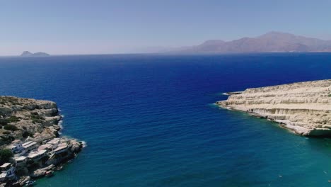 Hermosa-Vista-Desde-Un-Dron-Volando-Sobre-La-Playa-Y-La-Bahía-En-Matala-Creta-Grecia