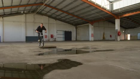 bmx rider in an empty warehouse