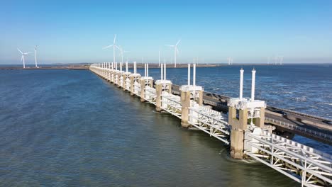 long aerial shot zooming out of the eastern scheldt storm surge barrier in zeeland, the netherlands, on a beautiful sunny day