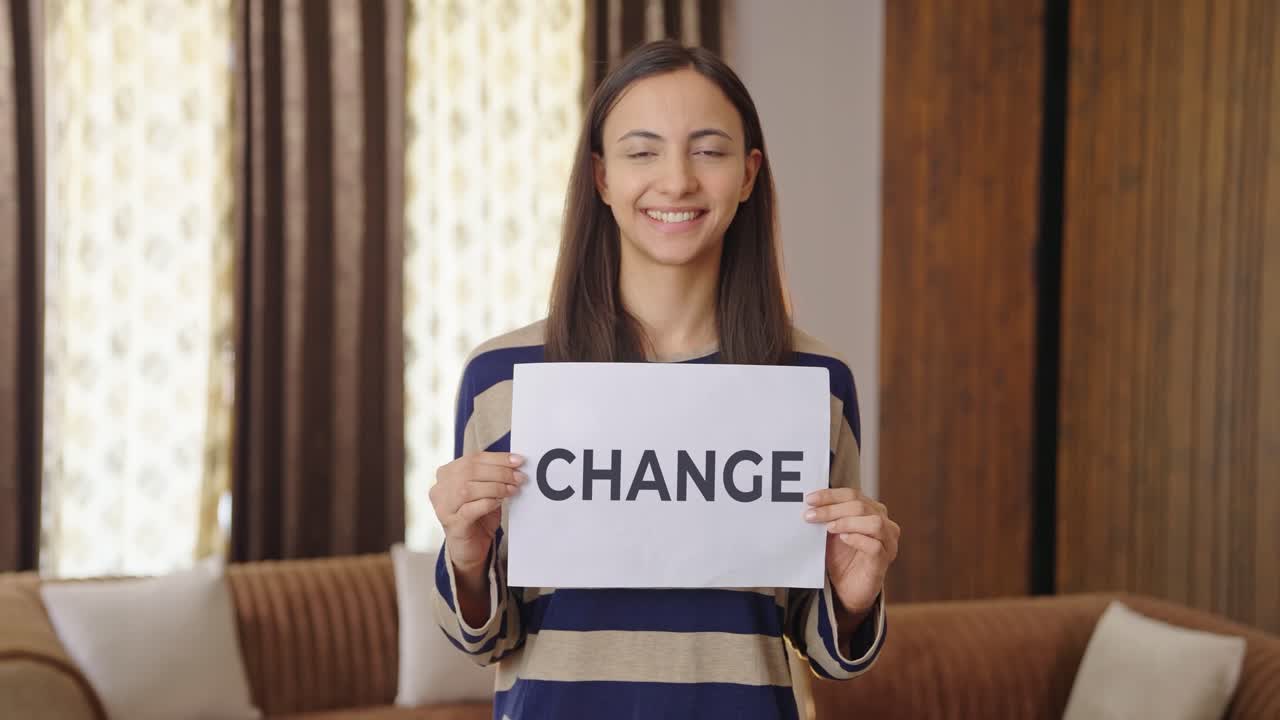 Happy Indian woman holding CHANGE banner