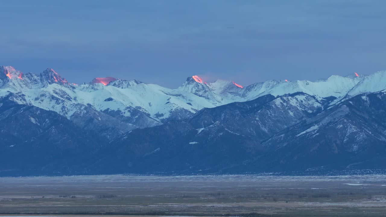 Hidas, elokuvamainen laskeutuminen avautuu näkymänä Coloradon karulle yläaavikolle kylmänä talviaamuna auringonnousun aikaan. Lumihuippuiset Rocky Mountain -vuoret muodostavat kaukaisen taustan kultaisessa valossa.