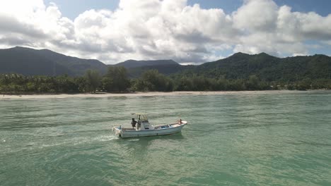 Pequeño-Barco-De-Motor-De-Pesca-De-La-Costa-De-La-Isla-Tropical-Tailandesa-Con-Montañas,-Cielo-Azul