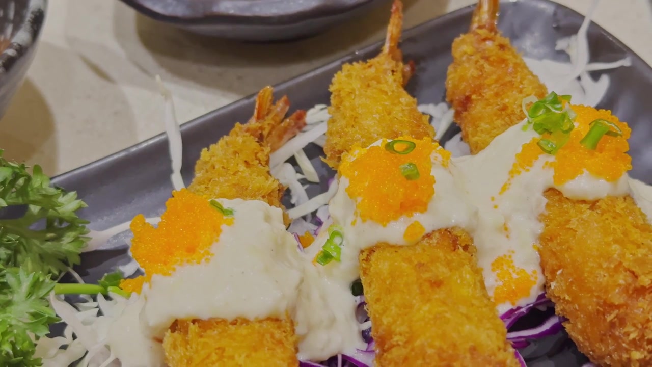 Vídeo em close-up de tempura japonês crocante lindamente servido em um prato tradicional. Frutos do mar e vegetais empanados dourados apresentados em um ambiente de jantar autêntico.