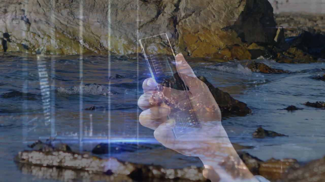 Holding smartphone over rocky shoreline, displaying digital data animation on screen