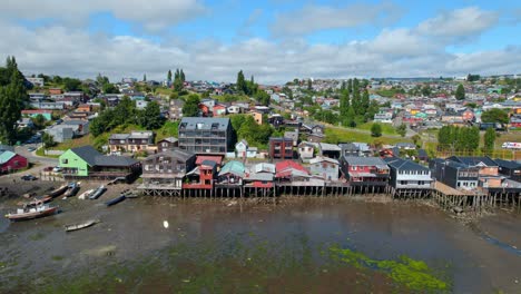 colorful stilt houses at castro houses and boats, cloudy skies, aerial view