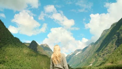 woman with arms outstretched enjoying a scenic norwegian fjord view