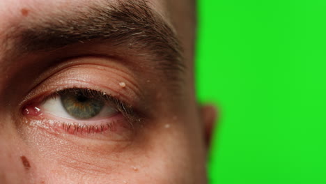close-up of a man's eye against a green screen background