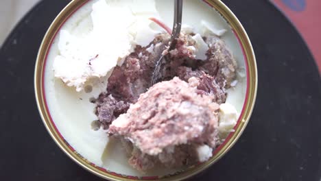 carne de cerdo estofada enlatada con una cuchara, girando de cerca