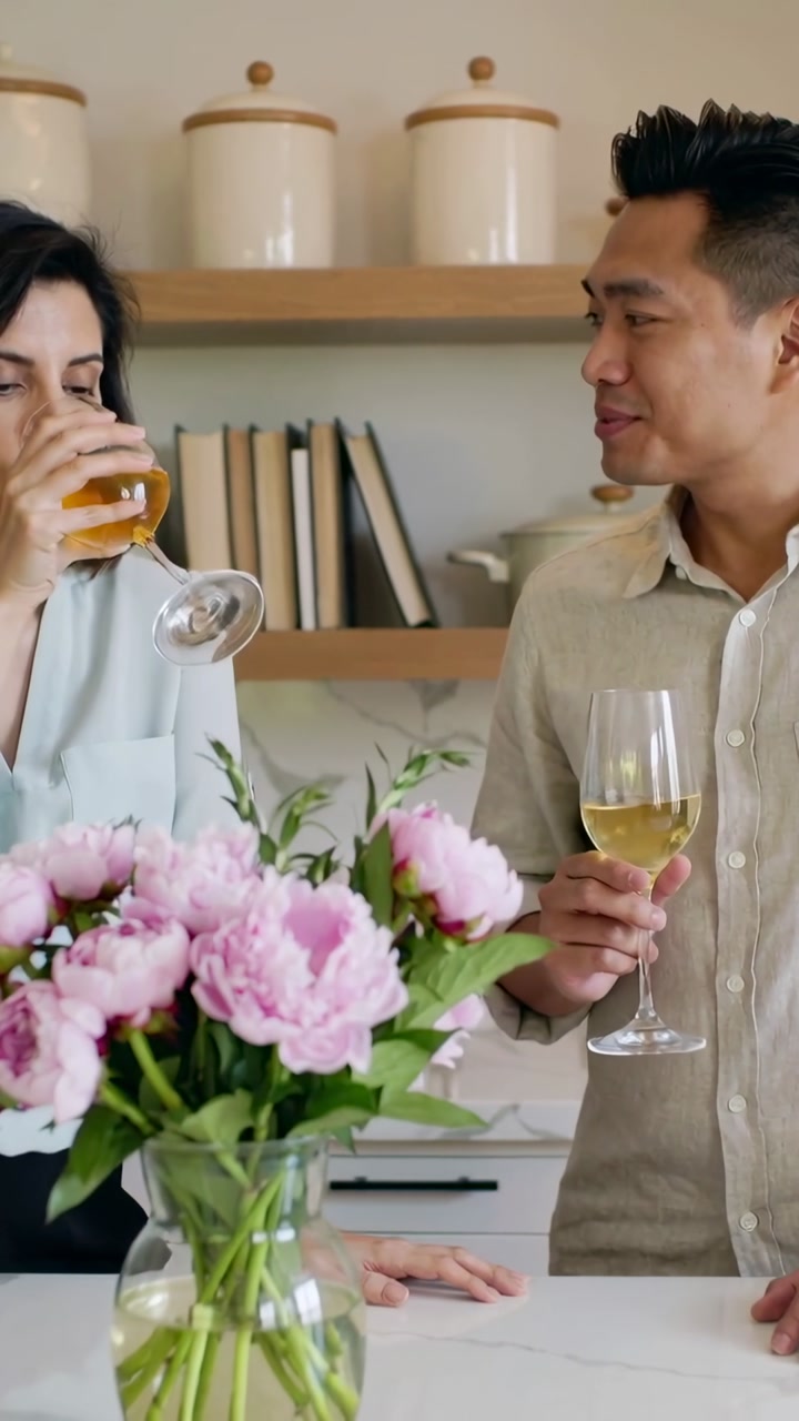 Happy Couple Enjoying Wine and Conversation in Modern Kitchen
