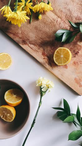 yellow flowers, lemon, and fresh herbs on a wooden cutting board