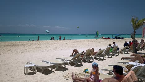 visitors bask in the warm sun on a stunning caribbean beach, surrounded by sparkling blue water and a serene atmosphere.