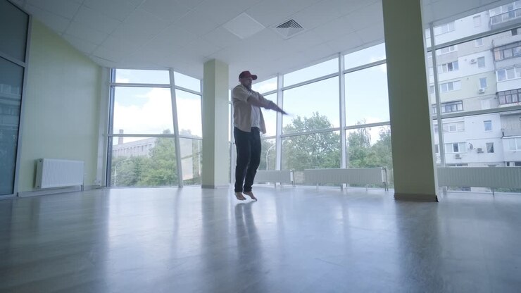 Giovane uomo elegante che balla break dance e coreografie. Concetto di performance, movimento, stile e moda
