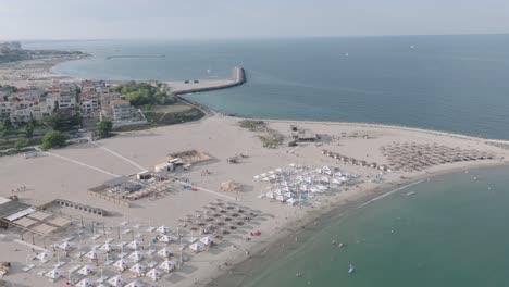 Parasols-On-The-Sandy-Shore-Of-Reyna-Beach-In-Constanța,-Romania