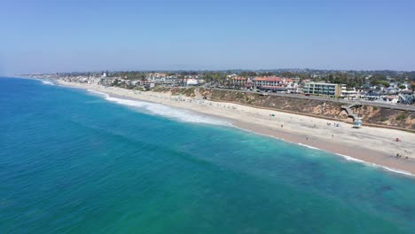 drone shot flying over the sea towards carlsbad state beach in california, usa